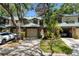 Charming townhome featuring a brick facade, green metal roof, garage and walkway to the front door at 1486 Mahogany Ln # 703, Palm Harbor, FL 34683