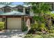 Exterior view of the home with a two-car garage, brick facade, well-manicured landscaping at 1486 Mahogany Ln # 703, Palm Harbor, FL 34683