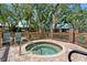 Inviting community hot tub surrounded by a fence and mature trees at 1486 Mahogany Ln # 703, Palm Harbor, FL 34683