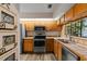 Bright eat-in kitchen features stainless appliances, tile countertops, and wood cabinets at 1486 Mahogany Ln # 703, Palm Harbor, FL 34683