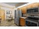 Eat-in kitchen featuring stainless appliances, light wood cabinets, tile counters, and casual dining area at 1486 Mahogany Ln # 703, Palm Harbor, FL 34683