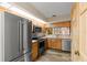 Kitchen featuring stainless appliances, light wood cabinets, tile counters, view of backyard through window at 1486 Mahogany Ln # 703, Palm Harbor, FL 34683