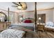 Primary bedroom featuring a four poster bed, elegant furnishings, and a ceiling fan at 1486 Mahogany Ln # 703, Palm Harbor, FL 34683