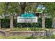 Community sign for Laurel Oaks surrounded by brick columns, black fence, and landscaping at 1486 Mahogany Ln # 703, Palm Harbor, FL 34683
