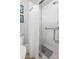 Bathroom featuring a tiled shower with a glass door and grab bar for assistance at 15 Tads Trl, Oldsmar, FL 34677