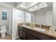 Bathroom featuring double sinks with granite countertops and dark wood cabinets at 15 Tads Trl, Oldsmar, FL 34677