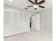 Bedroom featuring a ceiling fan, tile flooring, neutral paint, and a closet with bifold doors at 15 Tads Trl, Oldsmar, FL 34677