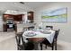 Well-lit dining area featuring a modern table set, a large window and view of kitchen at 15 Tads Trl, Oldsmar, FL 34677