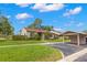 Beautiful single-story home with green lawn and covered carport in a sunny neighborhood at 15 Tads Trl, Oldsmar, FL 34677