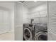 Convenient laundry area featuring a modern washer and dryer, with shelving for ample storage at 15 Tads Trl, Oldsmar, FL 34677