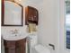 A quaint bathroom with a sink vanity, toilet, and a unique stained-glass window providing natural light at 1501 84Th N Ave, St Petersburg, FL 33702