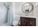 Cozy bathroom featuring a tiled shower, classic toilet and a patterned round mirror at 1501 84Th N Ave, St Petersburg, FL 33702