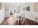 The dining room features hardwood floors, a modern chandelier, and a white dining set next to bright windows and doors at 1501 84Th N Ave, St Petersburg, FL 33702