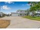 Inviting two-story home with a well-manicured lawn, charming front porch, and a spacious driveway leading to an attached garage at 1501 84Th N Ave, St Petersburg, FL 33702
