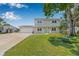 Inviting two-story home with a well-manicured lawn, charming front porch, and a spacious driveway leading to an attached garage at 1501 84Th N Ave, St Petersburg, FL 33702