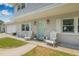 Charming front porch with a decorative door, white shutters, and two white Adirondack chairs for relaxing at 1501 84Th N Ave, St Petersburg, FL 33702