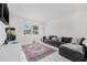 The room features light tile, a modern grey couch, neutral walls, and ample natural light from the window at 1501 84Th N Ave, St Petersburg, FL 33702