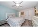Inviting bedroom featuring wood-look flooring, fan, light blue accent wall, and white furniture at 1715 Belleair Forest Dr # C, Belleair, FL 33756