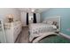 Bright bedroom with wood-look flooring, ceiling fan, blue accent wall, and white furniture at 1715 Belleair Forest Dr # C, Belleair, FL 33756