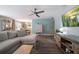 Bright living room featuring a ceiling fan, wood floors, and open access to the dining area at 1715 Belleair Forest Dr # C, Belleair, FL 33756