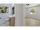 An elegant bathroom with a modern sink and vanity, plus a view into an adjacent room at 1857 Siesta Dr, Sarasota, FL 34239