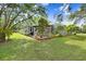 Expansive backyard showing screened-in lanai, pergola, and lush greenery creating a private outdoor retreat at 18929 Crescent Rd, Odessa, FL 33556