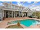 Stunning backyard with a screened-in pool and outdoor living spaces with a TV at 18929 Crescent Rd, Odessa, FL 33556