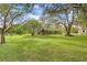 Large, well-maintained backyard with mature trees and landscaping, providing ample space and privacy at 18929 Crescent Rd, Odessa, FL 33556