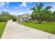 Landscaped yard and long driveway leading to a craftsman style home with a 3-car garage at 18929 Crescent Rd, Odessa, FL 33556