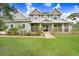 Two-story home featuring a charming front porch, lush landscaping, and freshly cut green lawn at 18929 Crescent Rd, Odessa, FL 33556