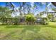 Spacious backyard with screened-in lanai, pergola, and lush landscaping, perfect for outdoor entertaining at 18929 Crescent Rd, Odessa, FL 33556