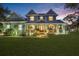 Beautiful two-story home featuring a cozy front porch, lush lawn, and warm exterior lighting at twilight at 18929 Crescent Rd, Odessa, FL 33556