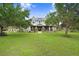 Inviting two-story home with a charming front porch and sprawling green lawn, framed by mature trees at 18929 Crescent Rd, Odessa, FL 33556