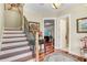Bright foyer with wood floors, staircase, and views into the living area with an open doorway to the bathroom at 18929 Crescent Rd, Odessa, FL 33556