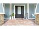 Charming front entrance with a dark wood door, brick patio, and decorative plants, creating a welcoming curb appeal at 18929 Crescent Rd, Odessa, FL 33556
