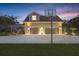 Two-car garage with a basketball hoop and exterior lighting, set against a stunning twilight sky at 18929 Crescent Rd, Odessa, FL 33556
