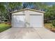 Detached two-car garage with white doors and ample parking space on a concrete driveway at 18929 Crescent Rd, Odessa, FL 33556