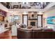 Cozy living room featuring a stone fireplace, plush leather sofa, and high ceilings with unique decor at 18929 Crescent Rd, Odessa, FL 33556
