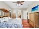 Comfortable main bedroom with wooden floors and furnishings, plus a ceiling fan and view to adjacent room at 18929 Crescent Rd, Odessa, FL 33556