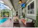 Charming covered outdoor living space overlooking a pool with a mounted television at 18929 Crescent Rd, Odessa, FL 33556
