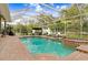 Inviting screened-in pool and spa surrounded by mature trees and a brick patio at 18929 Crescent Rd, Odessa, FL 33556