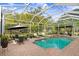 Beautiful screened-in pool with a spa and lush green surroundings at 18929 Crescent Rd, Odessa, FL 33556