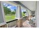 Inviting porch with stone columns, decorative railing, and comfortable seating overlooking a serene landscape at 18929 Crescent Rd, Odessa, FL 33556