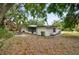 Side view of the house with an outdoor seating area, set amidst a natural, tree-filled environment at 2026 Cocoanut Ave, Sarasota, FL 34234