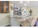 A stylish bar area with marble countertop, seating, shelving, decorative accents and a view into the kitchen at 2114 S Venus St, Tampa, FL 33629
