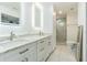 Modern bathroom with double sinks, marble countertops, LED mirrors and a separate shower at 2114 S Venus St, Tampa, FL 33629