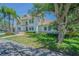 Side view of a white two-story home with a green lawn and mature trees on a sunny day at 2114 S Venus St, Tampa, FL 33629