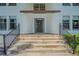 Inviting front entrance with stone steps leading up to a dark wood front door and black railings at 2114 S Venus St, Tampa, FL 33629