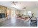 An open living room featuring a stone fireplace, hardwood floors, and lots of natural light at 2114 S Venus St, Tampa, FL 33629