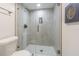 Walk-in shower with gray tiling, a glass door and a built-in shampoo nook at 2114 S Venus St, Tampa, FL 33629